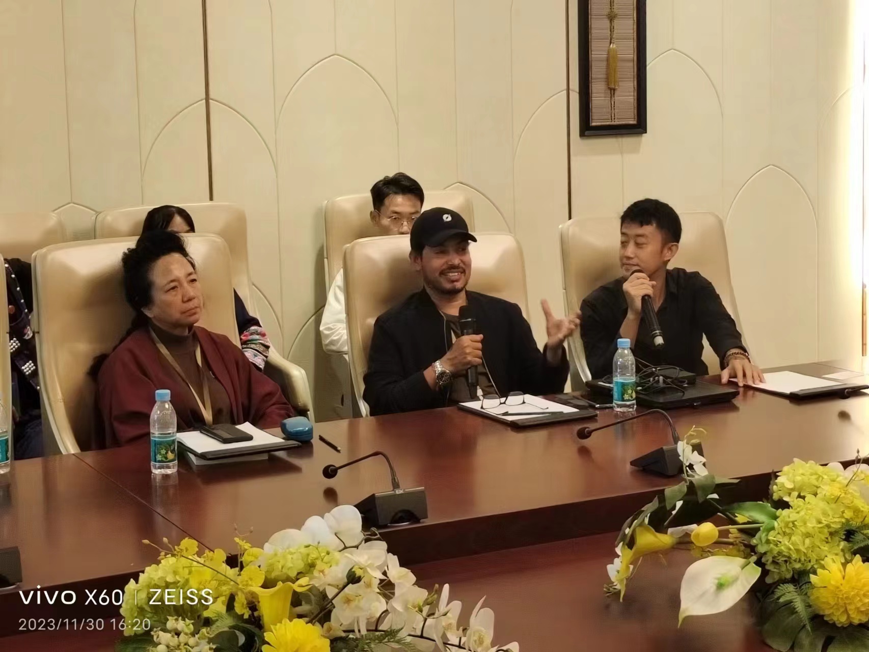 Delegates seated at a conference table with one speaker addressing the room through a microphone
